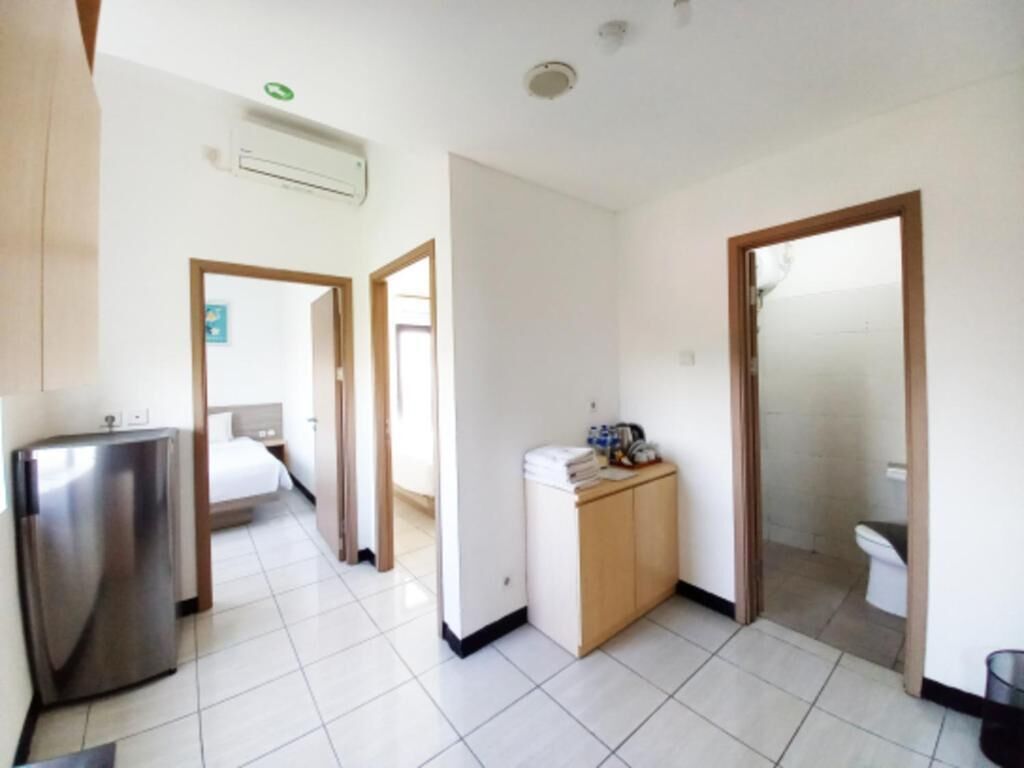 A hotel room with a bed, a desk, a wardrobe, and a bathroom.