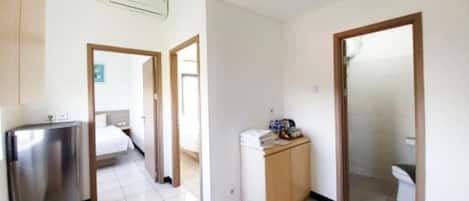 A hotel room with a bed, a desk, a wardrobe, and a bathroom.