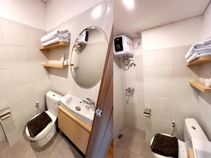 Een moderne badkamer met toilet, wastafel, spiegel, handdoekhouders en douche.