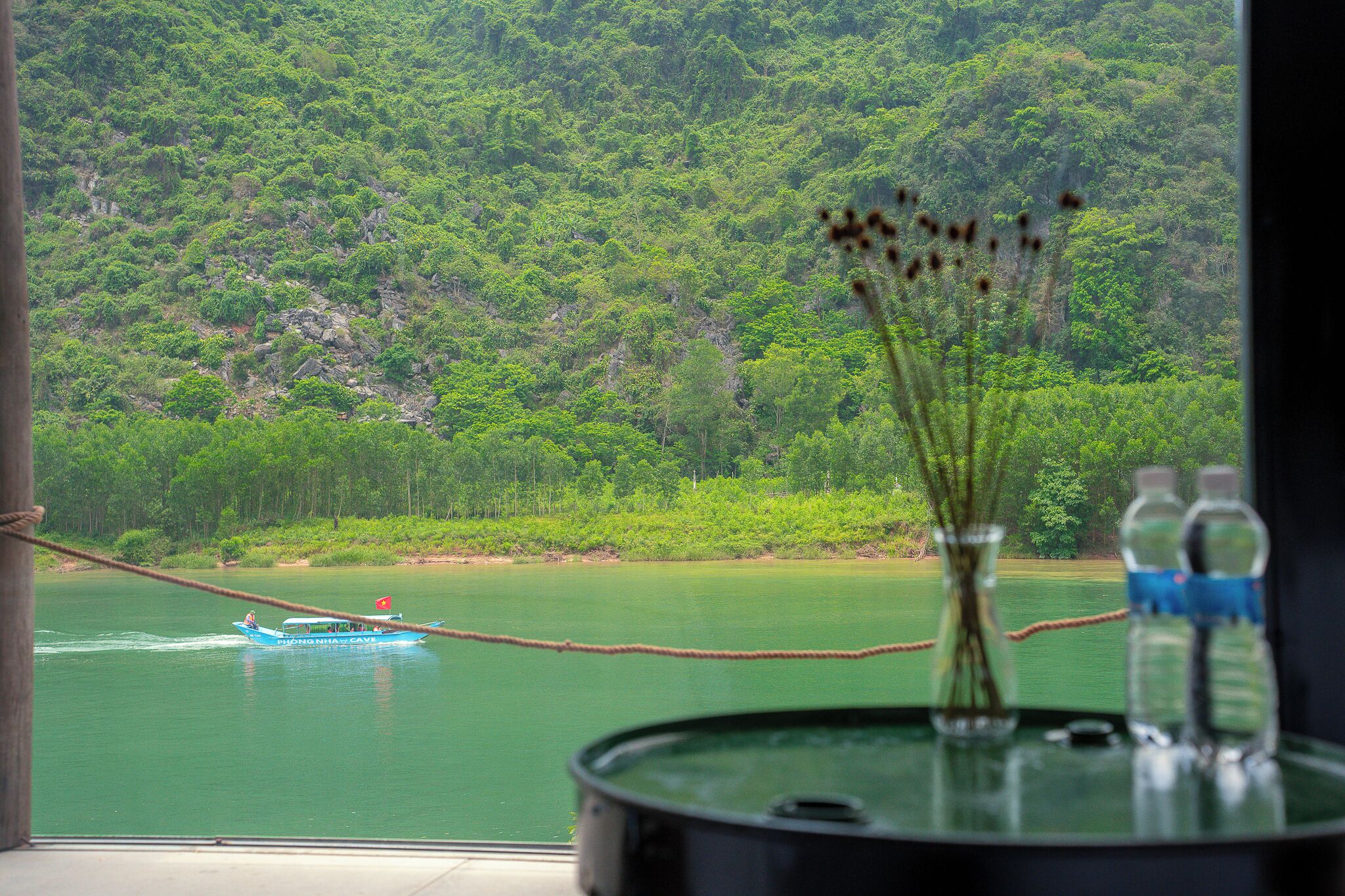 Vista de un río con un bote, rodeado de exuberante vegetación.