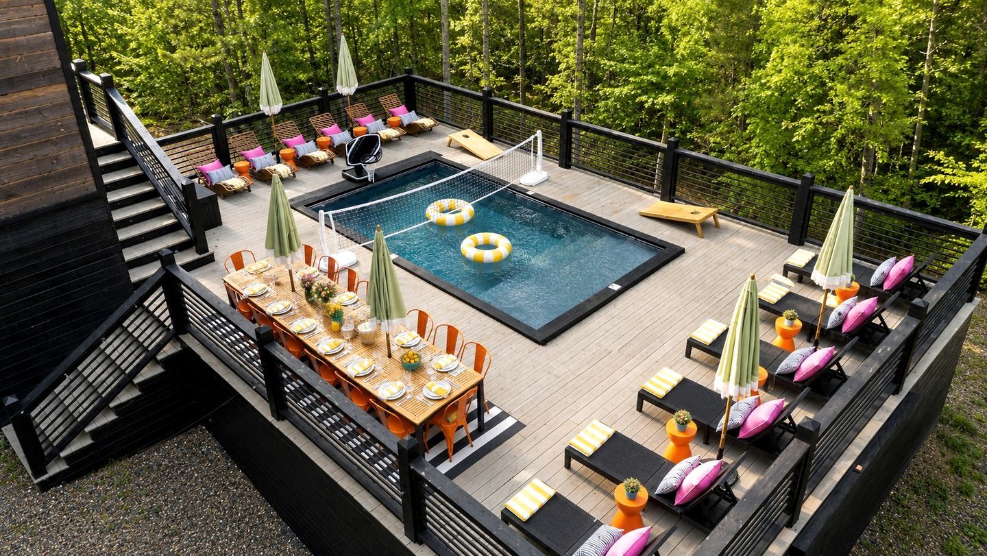 A rooftop pool area with a dining table set for six, lounge chairs, and a small pool table.