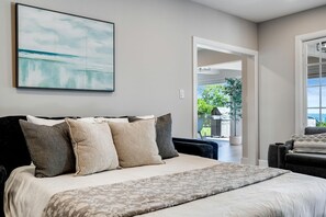A bedroom with a bed, pillows, a large window, and a view of the outdoors. - Cliffside Lakeview Villa with Saltwater Pool, Hot Tub & Epic Sunsets in Ontario, Canada (Kingsville)