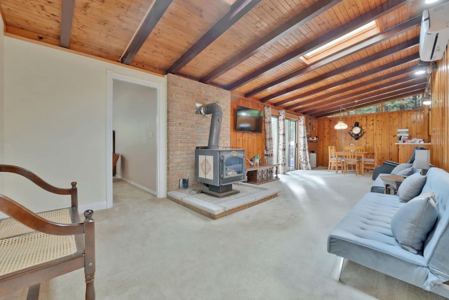 A cozy interior with a fireplace, a sofa, and a dining area.