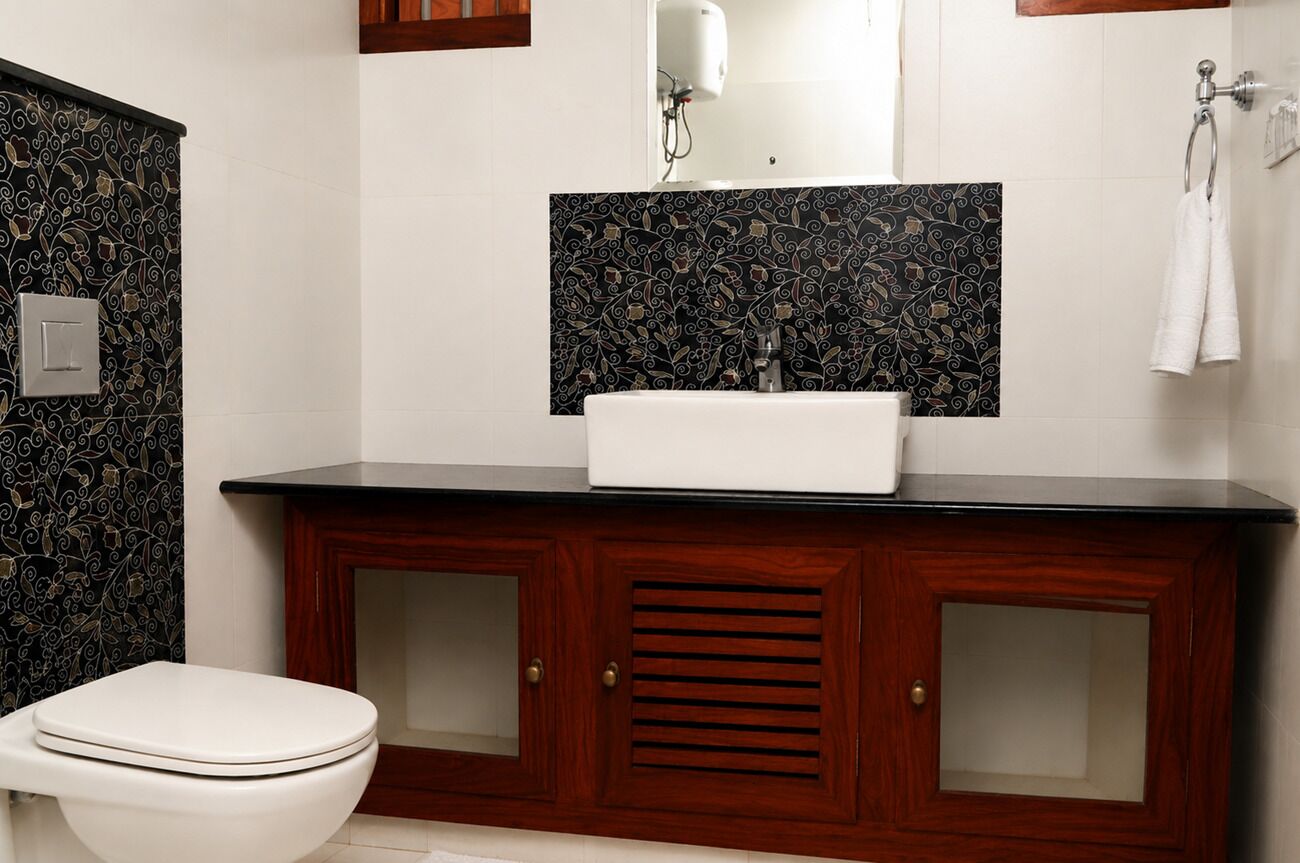 A bathroom with a toilet, a sink with a mirror above it, and a towel rack.
