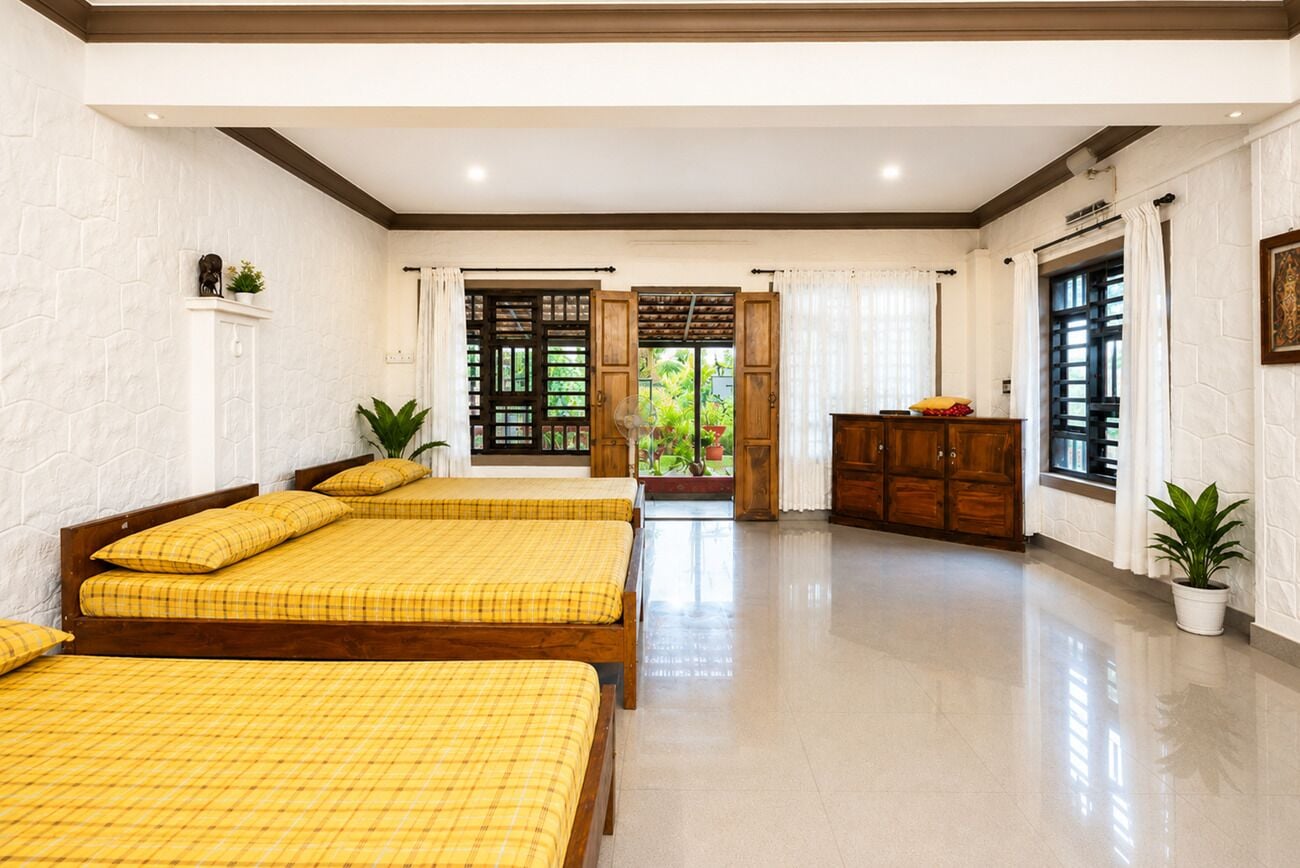 A hotel room with two beds, a wooden cabinet, and a view of the outdoors.