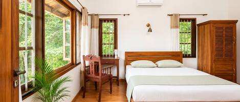 Un dormitorio con una cama de madera, un escritorio, una silla y una planta en maceta.