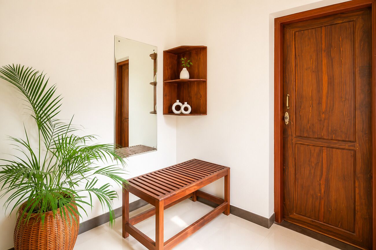 A wooden bench, a potted plant, a wooden door, and a wall-mounted shelf with decorative items.