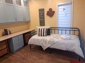 A bedroom with a bed, a desk, and a wardrobe. - Lakeside Vacation Rental on Lake Erie for a Unique Escape in Leamington, Ontario (Leamington)