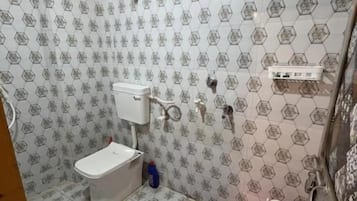 A bathroom with a toilet, a shower, and a sink.