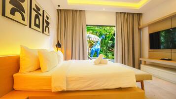 Quarto de hotel moderno com cama, televisão e vista para o verde lá fora.