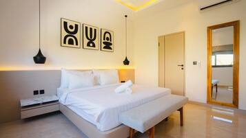 A modern bedroom with a bed, bedside tables, a bench, and wall art.