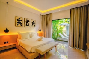 A modern bedroom with a bed, bedside lamps, artwork, and a view of greenery outside. - Modern Tropical Villa – 3BR & Private Pool (Badung)