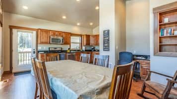 A spacious kitchen with wooden cabinets, a dining table, and chairs.