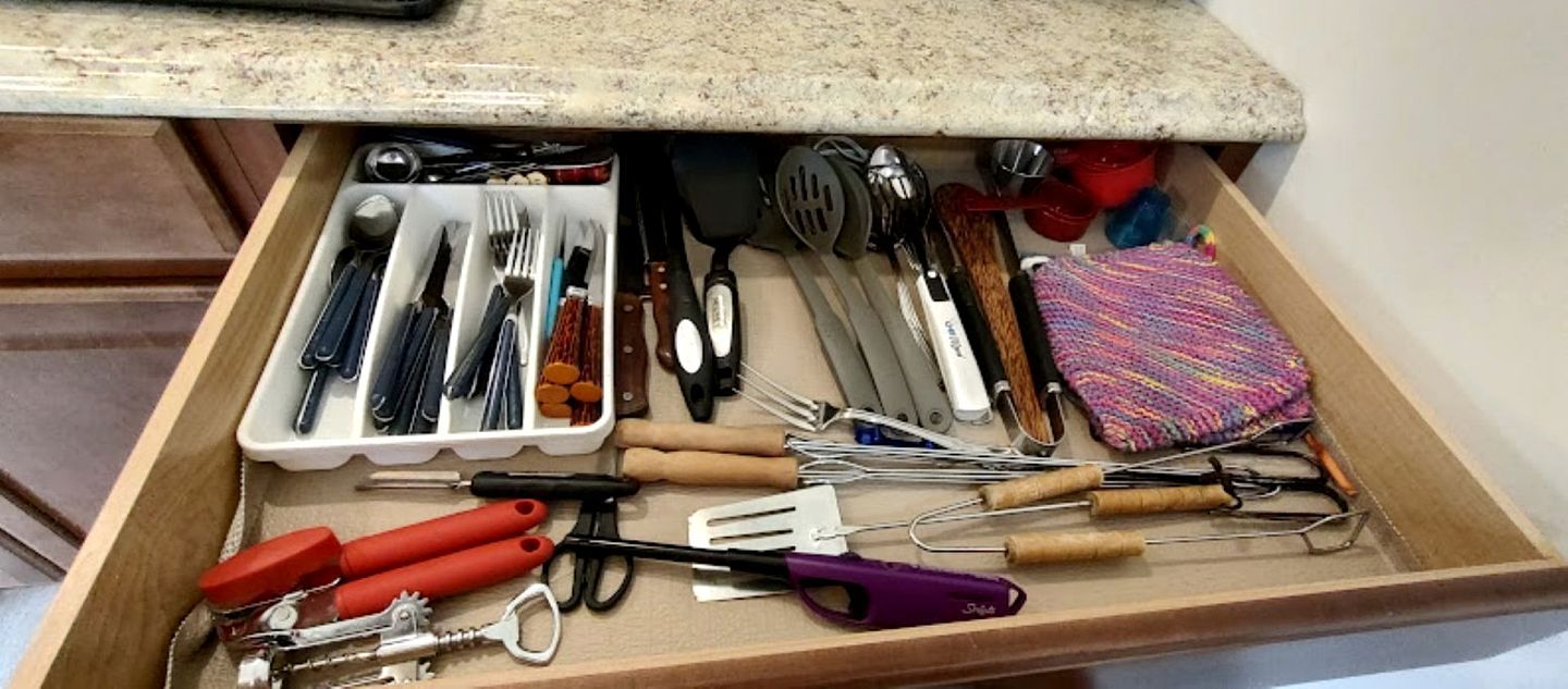 A drawer with various kitchen utensils and tools.
