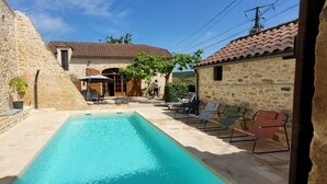 A stone building with a swimming pool, outdoor seating, and a clear sky. - La Grange du Sotoul - Large house for 10 people with all comforts and private swimming pool (Soturac)
