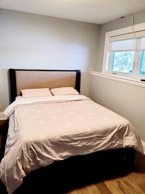 A single bed with a headboard, a window with blinds, and a wooden floor. - Spacious Lakefront Cottage with Private Boat Launch on Chemong Lake, Near Peterborough, Ontario (Harcourt)