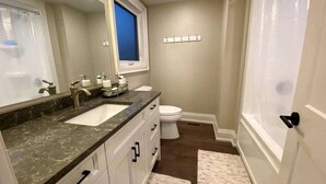 A bathroom with a sink, toilet, and shower curtain. - Spacious Lakefront Cottage with Private Boat Launch on Chemong Lake, Near Peterborough, Ontario (Harcourt)