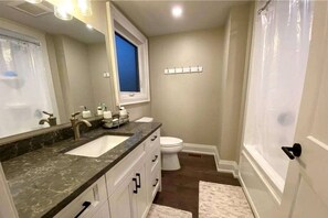 Un baño con lavabo, inodoro y cortina de ducha.