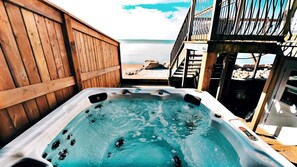 A hot tub with a view of the beach and a wooden deck. - Beachfront Cottage with Stunning Sights in Leamington, Ontario (Leamington)