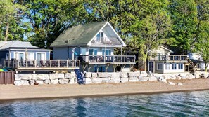 A waterfront property with a main house, a secondary building, and a dock. - Beachfront Cottage with Stunning Sights in Leamington, Ontario (Leamington)