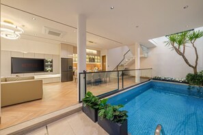 Ein modernes Interieur mit Pool, Netflix-Logo, einer Treppe und einem Essbereich.