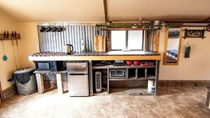 A compact kitchen with a microwave, refrigerator, and a small sink.