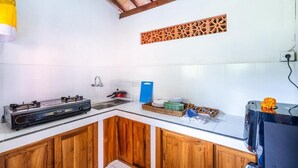 Uma cozinha com fogão a gás, micro-ondas e pia.