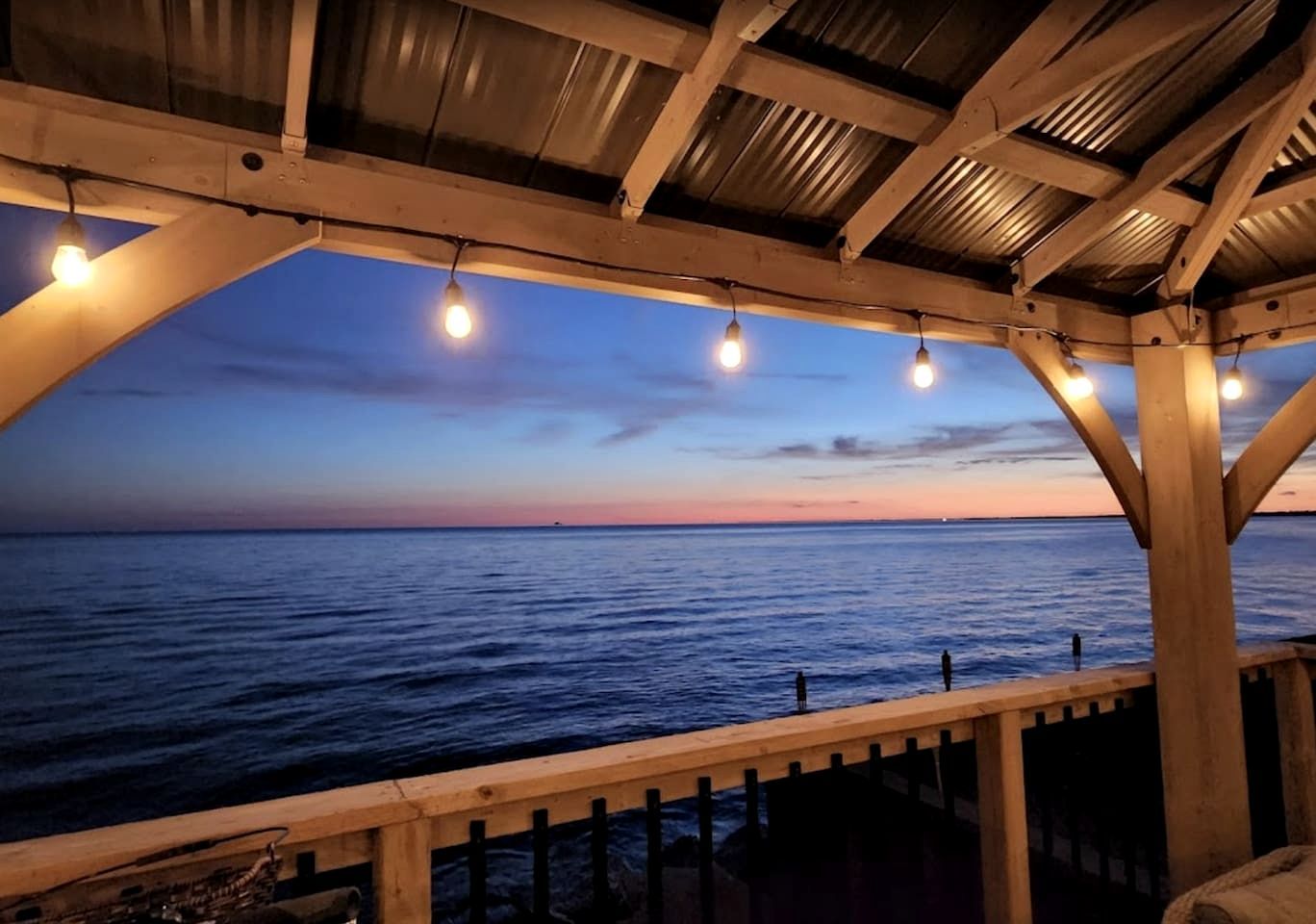 Une structure en bois offrant une vue sur la mer au crépuscule.