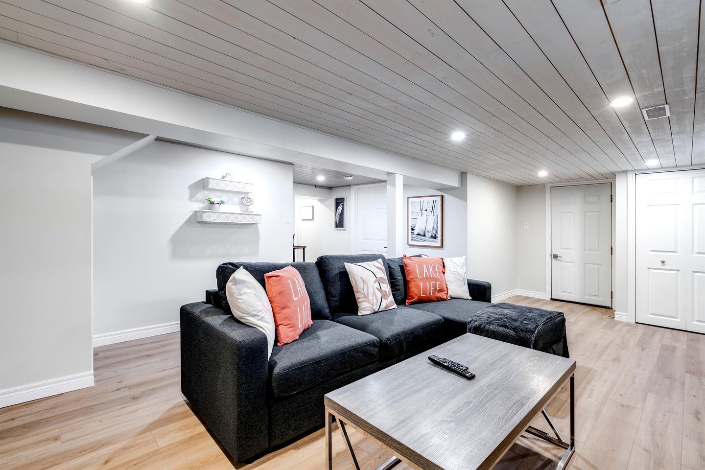 A modern living room with a sectional sofa, a coffee table, and a fireplace.