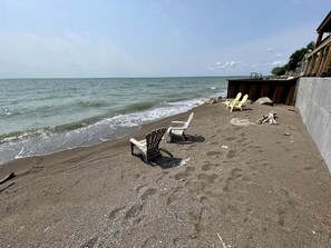 A beach with chairs and a concrete wall.