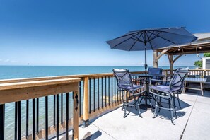 Une terrasse dotée de mobilier d’extérieur et offrant une vue sur l’océan.