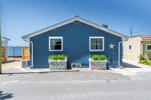 A single-story house with a gabled roof, two windows, and a star decoration on the wall.