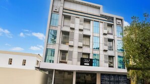 A multi-story building with a modern architectural design, featuring large windows and a signboard on the ground floor. - Collection O Shirdi Near Sai Baba Temple (Rahata)