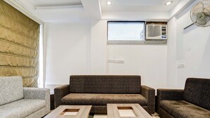 A modern living room with a brown sofa, two wooden coffee tables, and a grey sofa. - Collection O Shirdi Near Sai Baba Temple (Rahata)