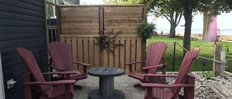 Un patio al aire libre con sillas Adirondack y una mesa redonda.
