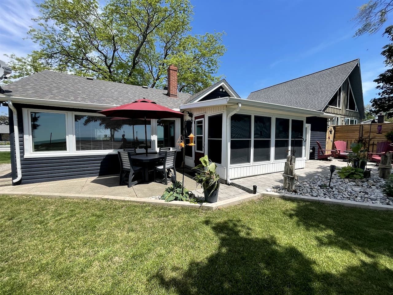 A house with a covered patio, a fenced yard, and a small garden area.