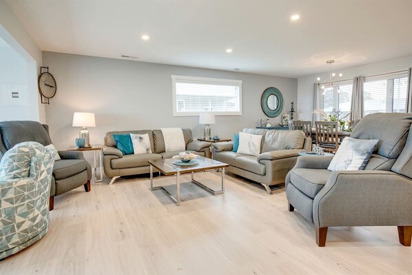 A modern living room with two sofas, a coffee table, and a side table with a lamp.