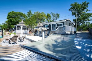 A residential property with a covered patio, outdoor seating, and a small gazebo. - Gorgeous Cottage with Fire Pit and Nice Beach Vistas in Leamington, Ontario (Leamington)