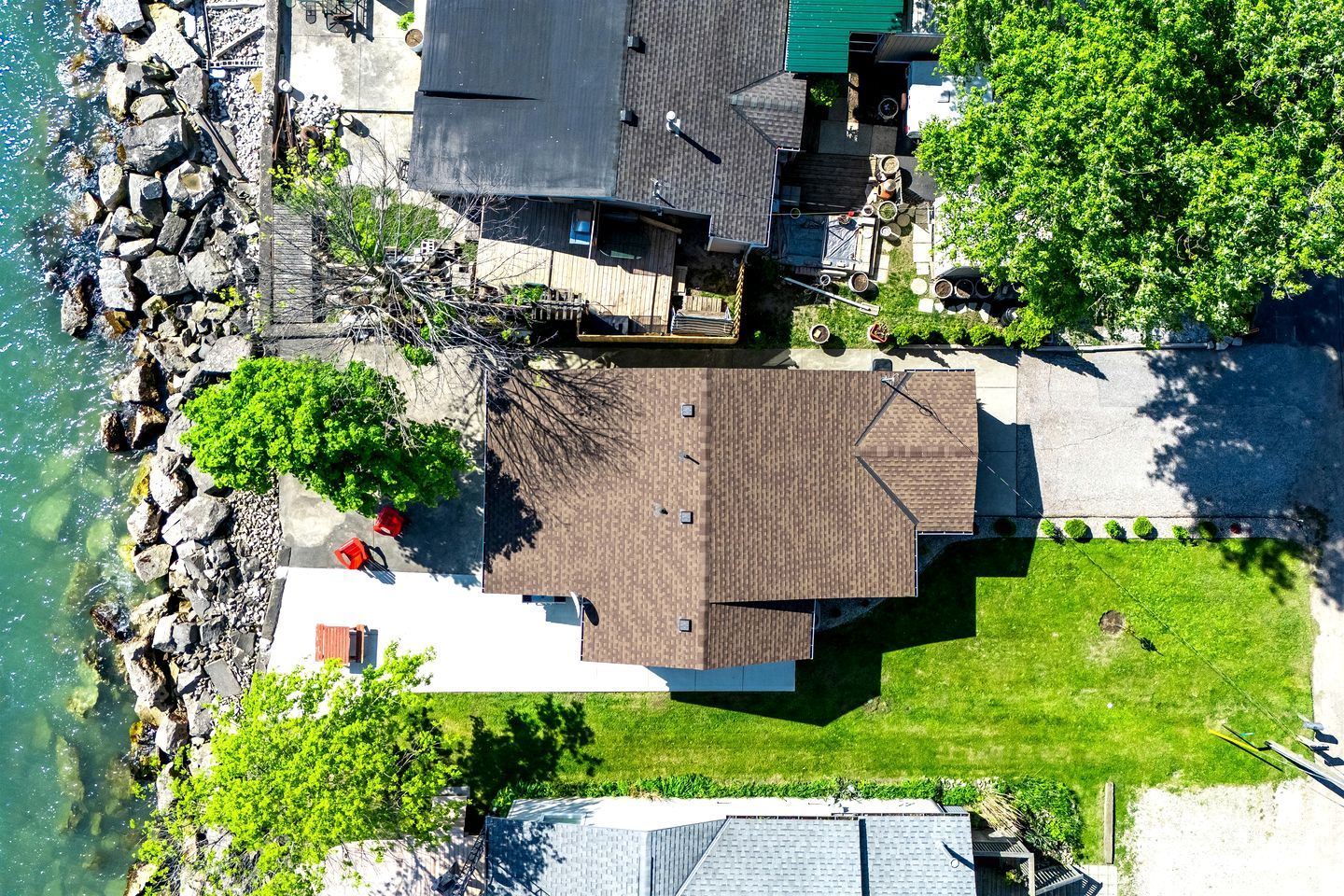Ett flygbildsbild av ett bostadsområde med ett hus, en brygga och en gräsyta.
