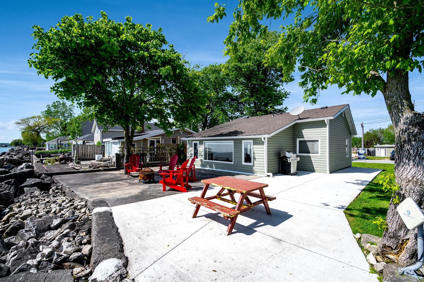 A residential area with houses, a picnic table, and a fire pit.