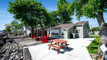A residential area with houses, a picnic table, and a fire pit.