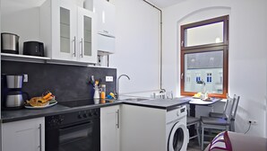 Cocina compacta con estufa, horno, microondas y lavadora.