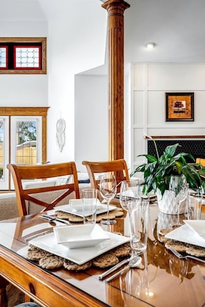 A dining area with a wooden table set for two, a large column, and a fireplace. - Luxurious Vacation Rental near Lake Erie for an Amazing Family Retreat in Leamington, Ontario (Leamington)