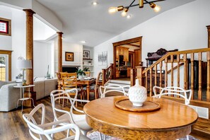 A spacious living room with a dining area, wooden staircase, and a view of the kitchen. - Luxurious Vacation Rental near Lake Erie for an Amazing Family Retreat in Leamington, Ontario (Leamington)