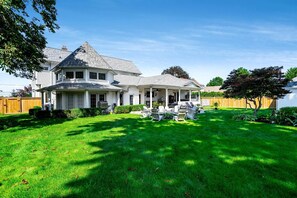 A two-story house with a covered porch and a well-maintained lawn. - Luxurious Vacation Rental near Lake Erie for an Amazing Family Retreat in Leamington, Ontario (Leamington)