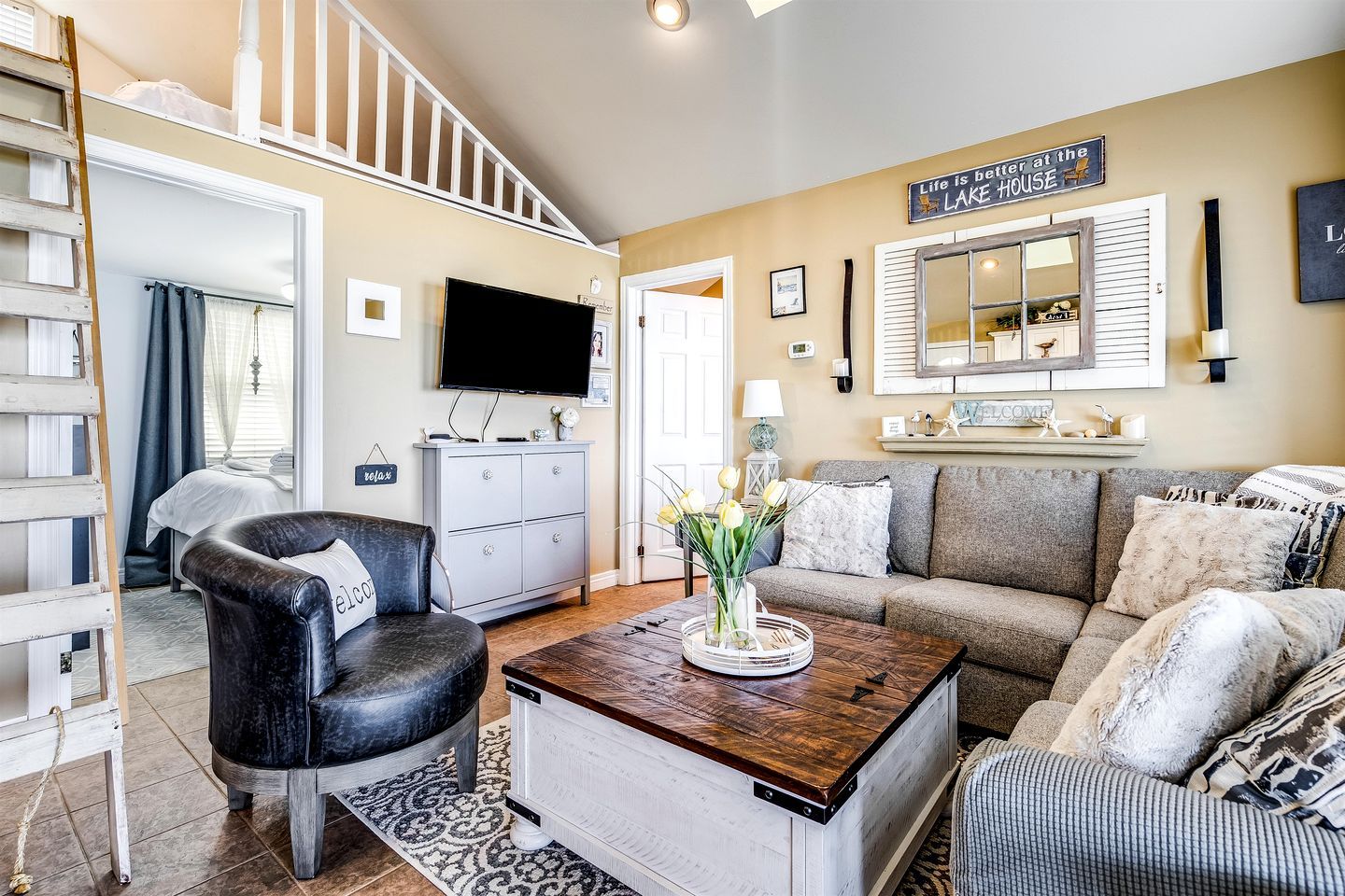 A living room with a sofa, a coffee table, a TV, and a staircase.