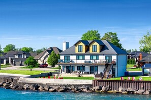 A waterfront residential area with modern houses, a dock, and a clear blue sky. - Charming Lakefront Vacation Rental on Lake Erie for a Memorable Family Escape in Leamington, Ontario (Leamington)