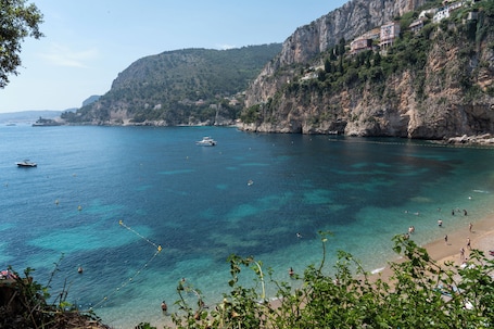 Un paysage côtier avec une eau claire, des bateaux et des bâtiments situés sur une falaise.. Hôtel de Monaco