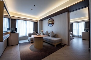 A modern hotel room with a sofa, a round coffee table, a TV, and a large window. - Crystal Orange Hotel Chengdu Wuhouci Hongpailou (Chengdu)