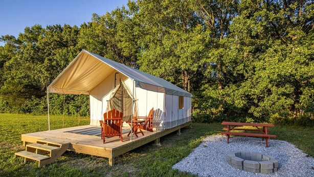 Acomodação em tenda com deck, cadeiras e mesa para piquenique.